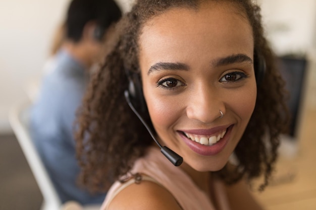 Executiva com fones de ouvido sorrindo no escritório