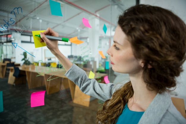 Executiva feminina escrevendo em post-its