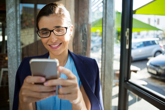 Executiva feminina usando telefone celular em um café