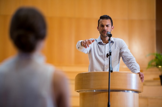 Foto executivo de negócios apontando para o público ao fazer um discurso