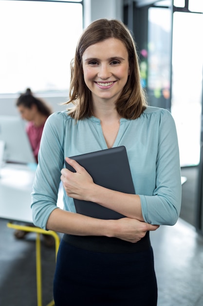 Foto executivo empresarial em pé com tablet digital no escritório