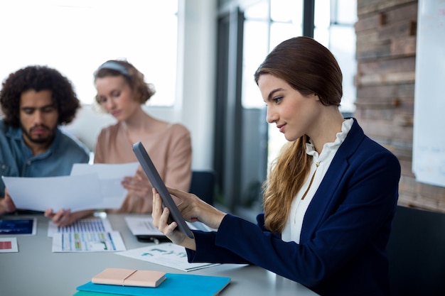 Executivo empresarial feminino usando tablet digital no escritório