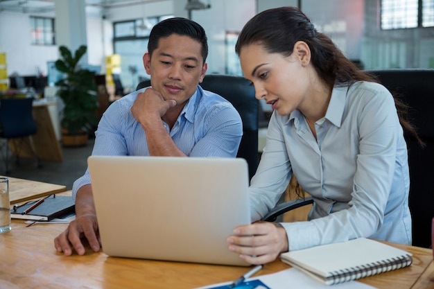 Executivos de negócios, discutindo sobre laptop