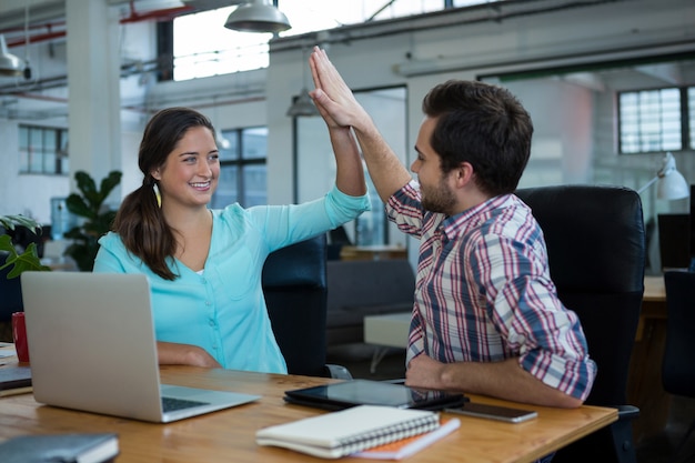 Executivos de negócios feliz dando mais cinco na mesa