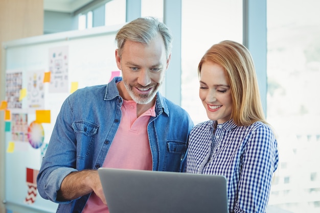 Executivos de negócios masculinos e femininos usando laptop