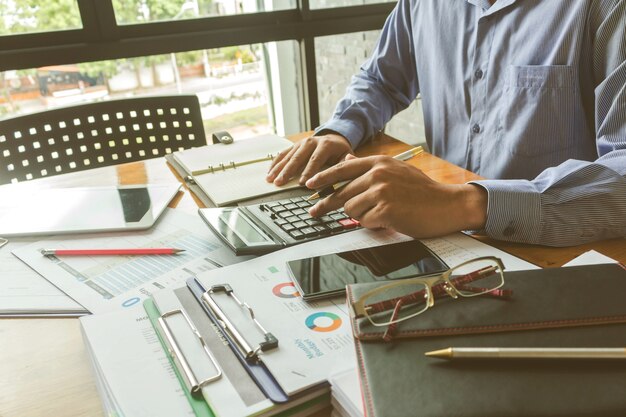 Executivos de negócios, trabalhando na calculadora com o documento de dados no escritório