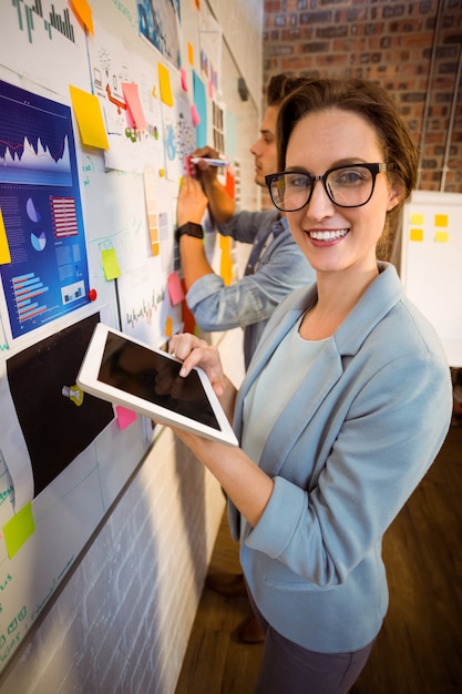 Foto executivos de negócios usando tablet digital e escrevendo em notas autoadesivas