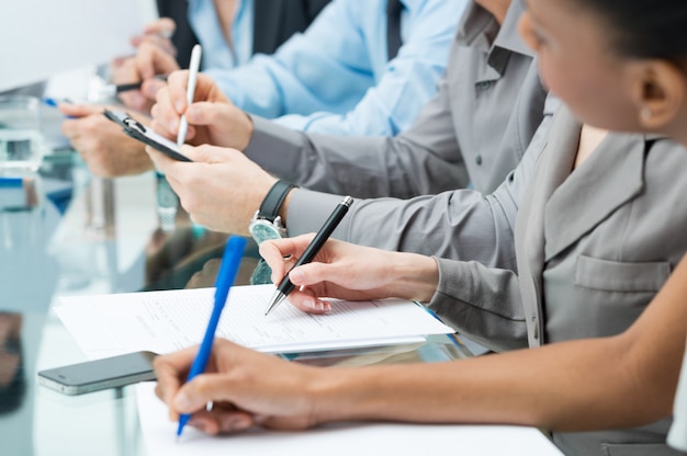 Executivos Escrevendo Nota na Reunião