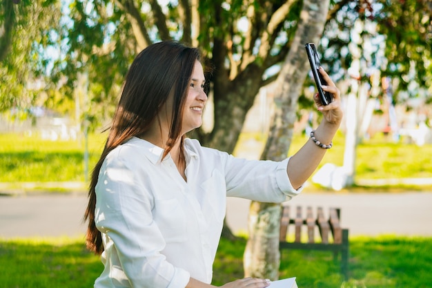 Exekutive Frau, die ein Selfie mit ihrem Telefon am Park nimmt