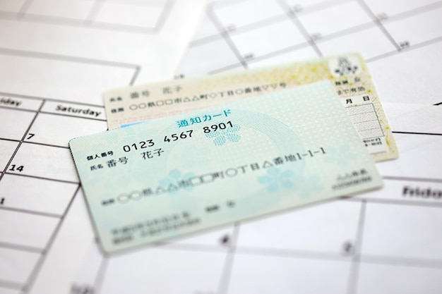Foto exemplar de meu cartão de número japonês e cartão de notificação em fundo de calendário em close-up