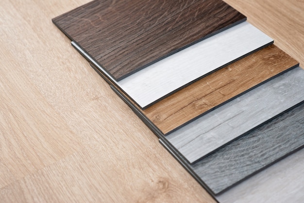 Exemplo de catálogo de pisos de vinil de luxo com um novo design de interiores para uma casa ou piso em uma mesa de madeira clara.