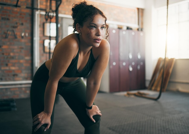 Foto exercício cansado e mulher na academia após treino físico ou treinamento para saúde e bem-estar do corpo jovens esportes femininos ou atletas descansando no intervalo enquanto pensam em metas de progresso e desempenho