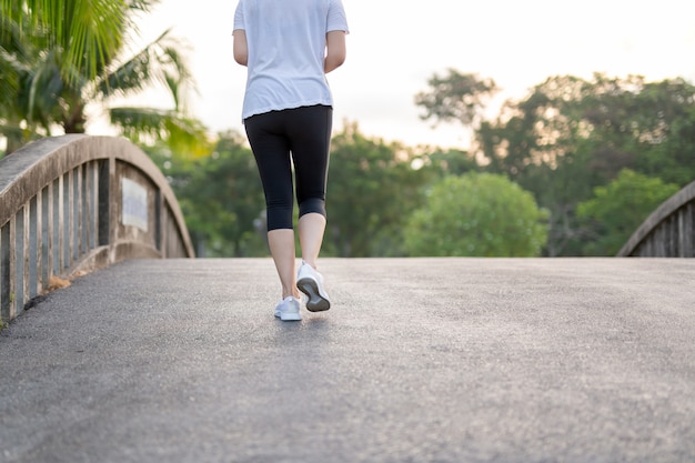 Exercício da mulher que anda no parque na manhã.