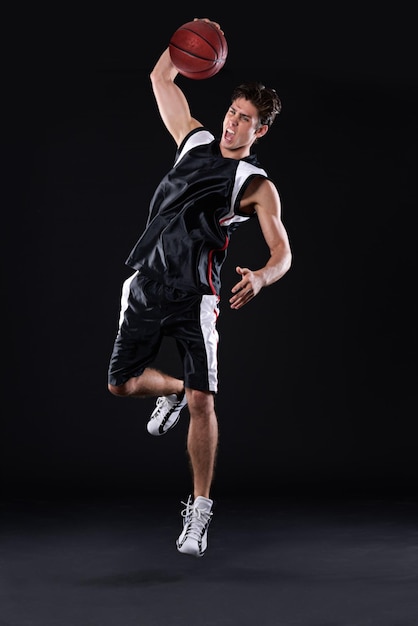 Exercício de basquete e salto de homem em estúdio para treinamento energia e aptidão corporal saudável isolados em fundo preto Jogador de esportes e atleta atirando bola ou competição dunk e espaço de maquete