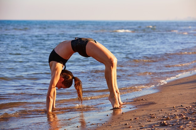 Exercício de treino de yoga Pilates ao ar livre na praia