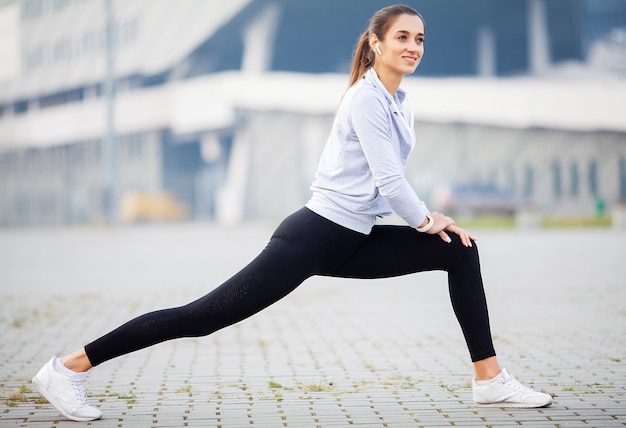 Exercício desportivo da menina no parque na cidade moderna