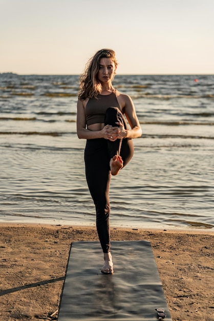 Exercício favorito yoga asana ao ar livre ao pôr do sol uma mulher treina um corpo flexível Usa antiderrapante