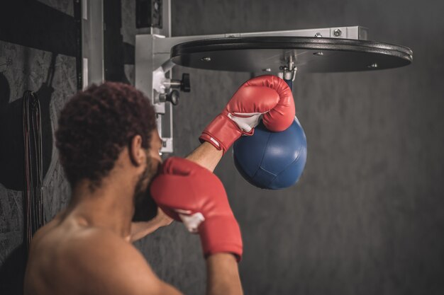 Exercício. kickboxer afro-americano se exercitando em uma academia trabalhando em seus chutes