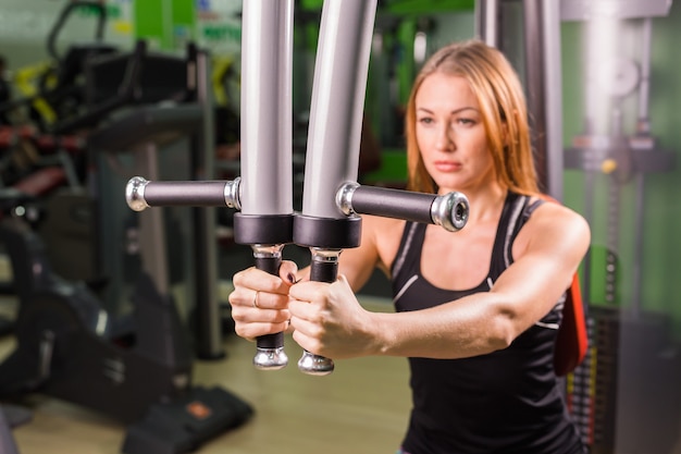 Foto exercício muscular bonito da mulher do ajuste