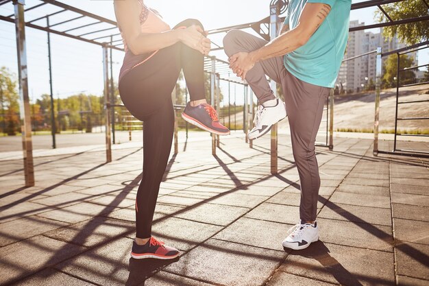 Exercícios de alongamento foto recortada de homem e mulher em roupas esportivas se aquecendo enquanto