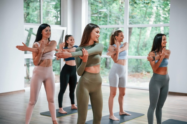 Exercícios de aquecimento Grupo de mulheres praticando fitness na academia