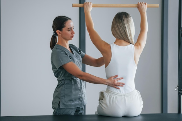 Foto exercícios de coluna mulher está no centro de saúde recebendo ajuda do médico