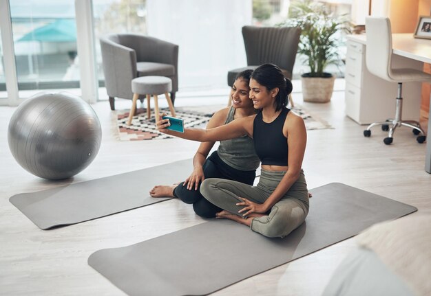 Exercite selfie de fitness e mulheres juntas em casa para memória de mídia social ou poste irmãs indianas ou amigas no lounge com uma foto para motivação de treino de atualização de influenciador ou resultados felizes