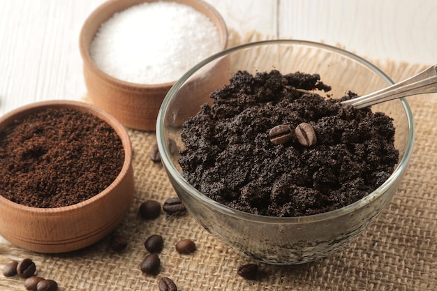 Exfoliante de café casero en un frasco para la cara y el cuerpo y varios ingredientes para hacer un exfoliante sobre un fondo claro cosméticos para el cuidado de los cosméticos de spa