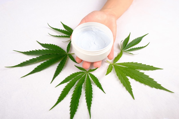 Exfoliante corporal en mano con hojas de cannabis