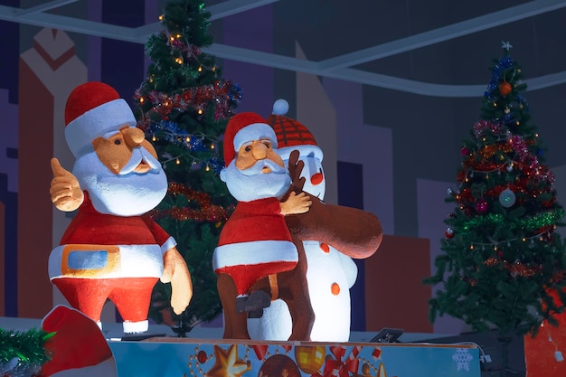 Exhibición de 2 muñecos de Papá Noel y adornos navideños con iluminación en el área del centro comercial