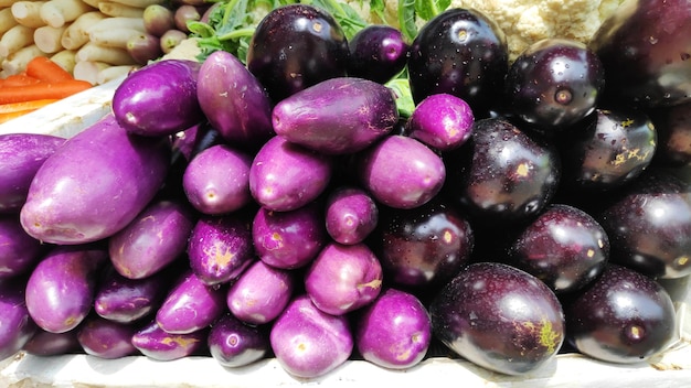 Exhibición de berenjena madura cruda en puesto de verduras