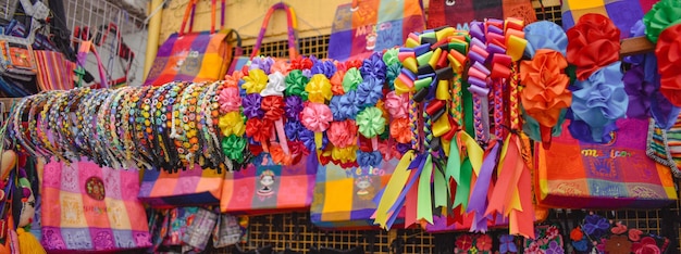 Una exhibición de coloridos bolsos con cintas de colores y flores.