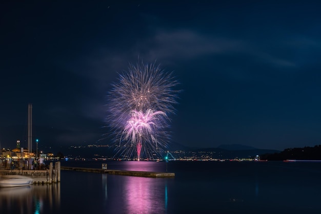 Exhibición de fuegos artificiales por el mar por la noche