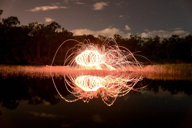 Exhibición de fuegos artificiales sobre el lago contra el cielo por la noche