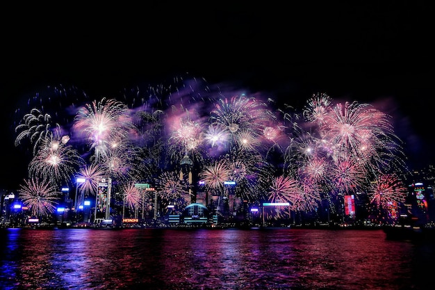 Exhibición de fuegos artificiales sobre el mar contra el cielo por la noche