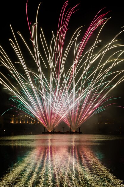 Foto exhibición de fuegos artificiales sobre el río por la noche