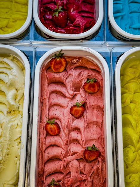 Foto una exhibición de helados de diferentes colores con fresas y fresas