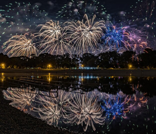 Foto exibição de fogos de artifício sobre o lago à noite