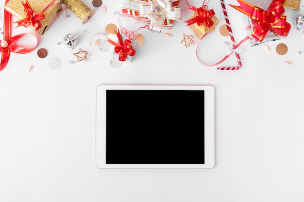 Exibição de tablet na mesa com tela branca isolada para maquete no horário de Natal