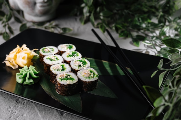 Exibição elegante de rolo de sushi em prato preto