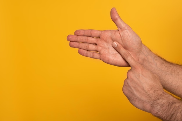 Exibição recortada de mãos masculinas mostrando gesto em linguagem surda e muda isolada em amarelo