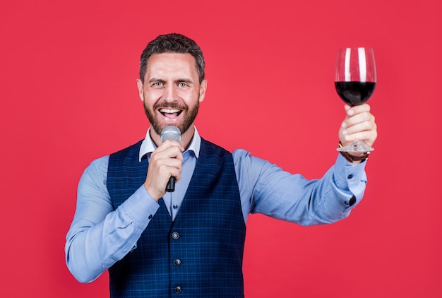 Exijo que o banquete continue. toastmaster fala ao microfone levantando uma taça de vinho. fazendo um banquete. cerimônia ou celebração. falar em público. arte oratória. habilidade na fala.