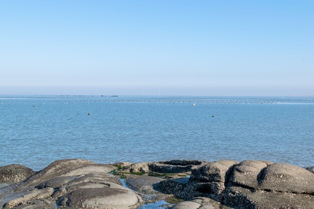 Existem todos os tipos de recifes à beira-mar, céu azul e água do mar