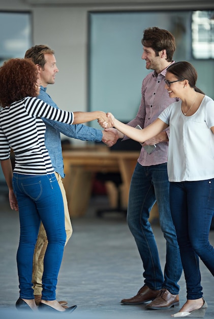 Foto Éxito de apretón de manos o gente de negocios en el inicio para apoyo de colaboración o acuerdo de trato grupo de hombres mujeres felices o equipo de empleados creativos dándose la mano en una asociación o negociación