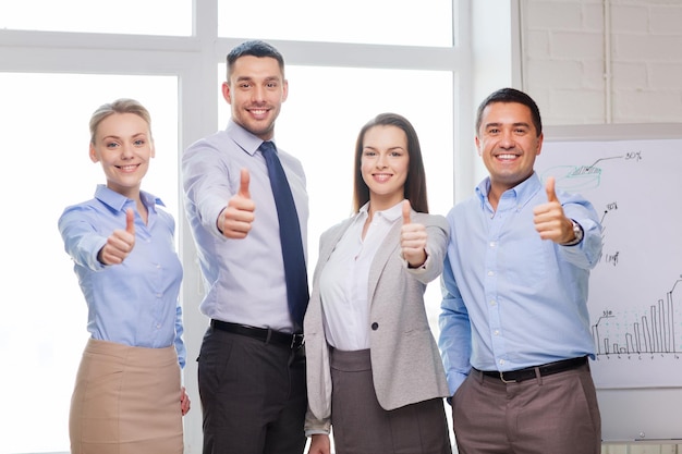 éxito, negocios, oficina y concepto ganador - equipo de negocios feliz mostrando su aprobación en la oficina