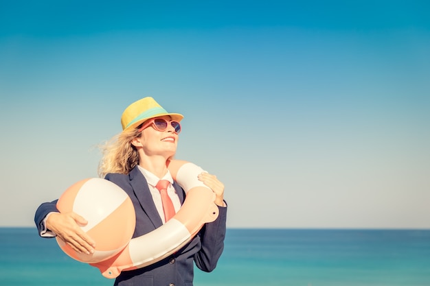 Exitosa empresaria en la playa Mujer joven contra el mar y el cielo