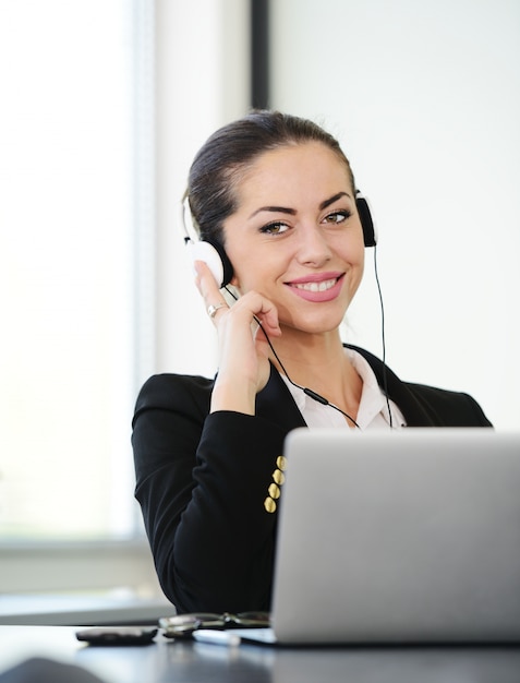 Foto exitosa mujer de negocios con auriculares