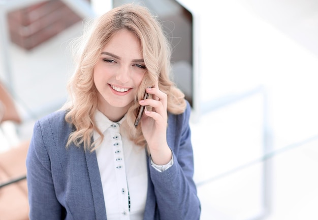 Foto exitosa mujer de negocios joven sentada en un escritorio