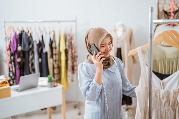 exitosa mujer de negocios musulmana como diseñadora de moda llamando por teléfono