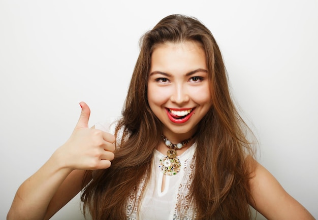 Exitosa niña feliz da pulgar hacia arriba con las dos manos